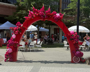 Red floral archway in an outdoor setting for events